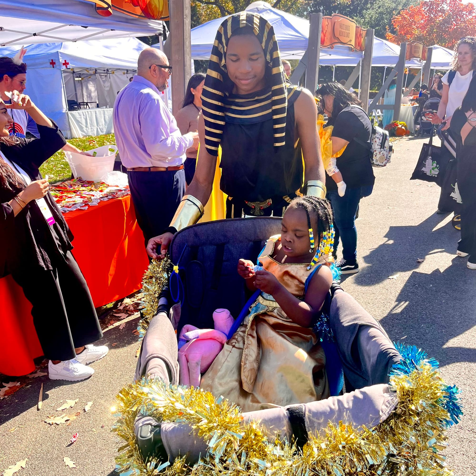 Egyptian princess Destiny rides in style as her brother the Pharaoh pushes her “chariot” to collect treats