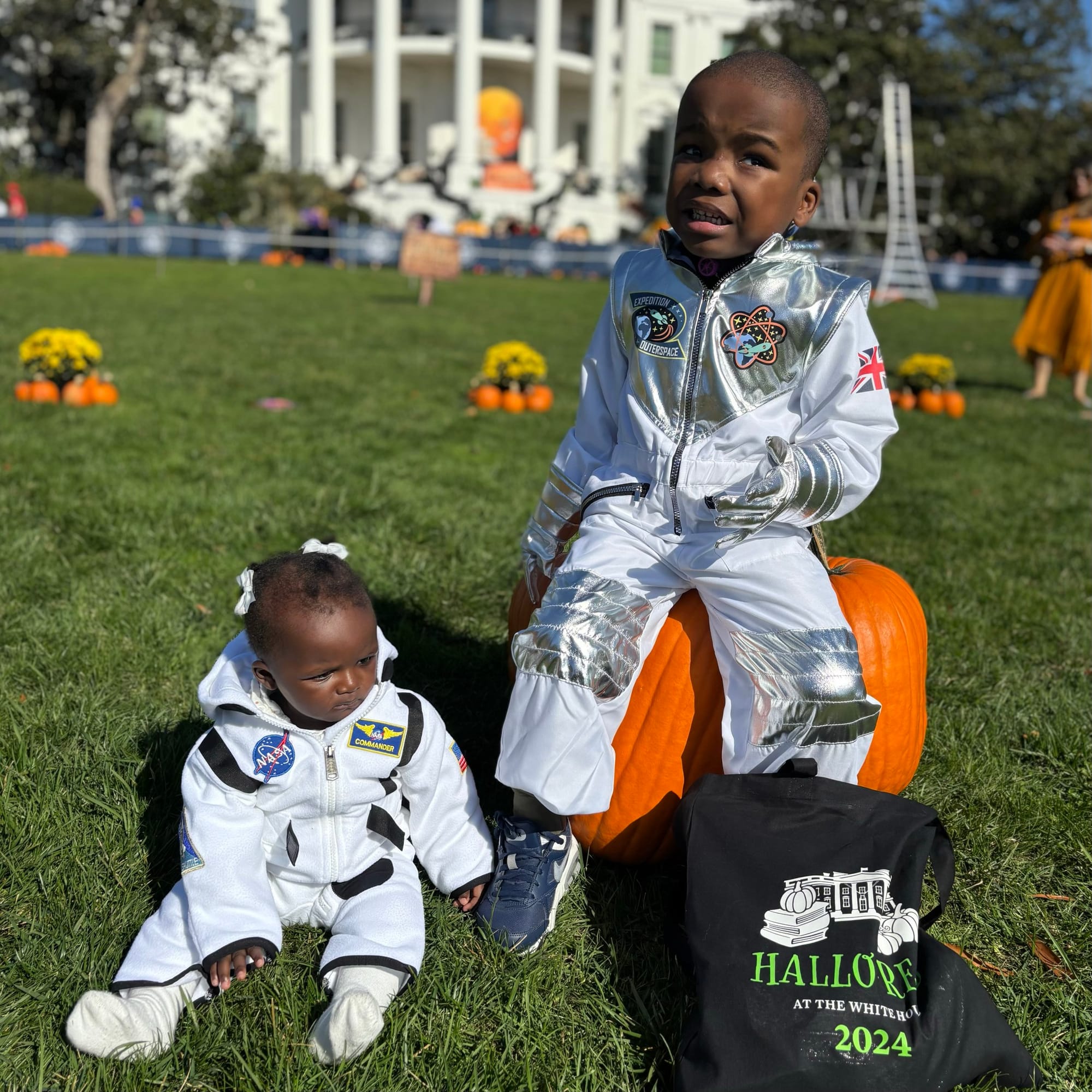 Two cute astronauts (Little Lobbyists Adonise and his sister Adriande ) take a break from NASA to sit on the White House lawn and check out the treats they collected