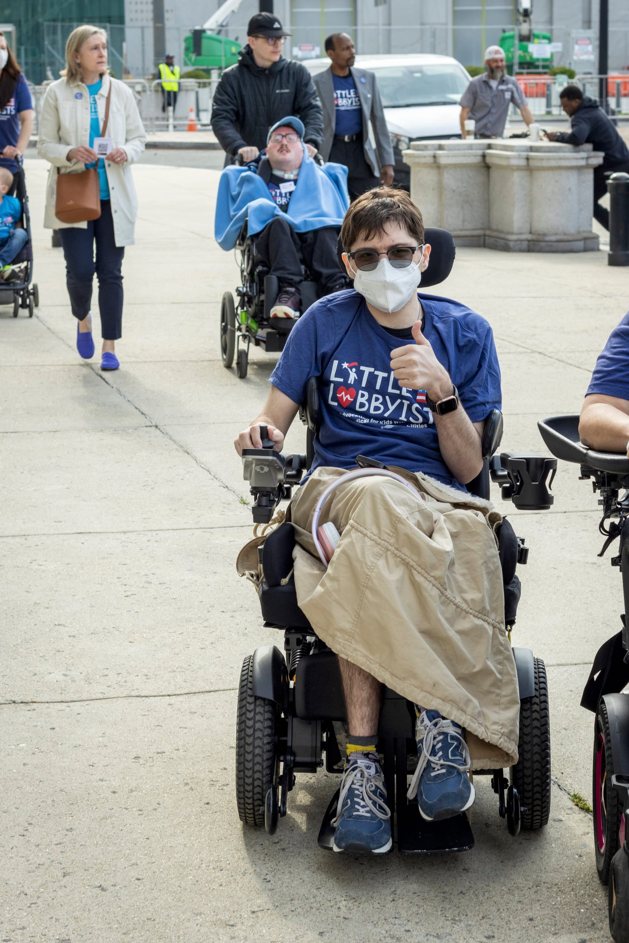 Kody, rolling along in his wheelchair, gives a thumbs-up as our group is escorted into the rally. Jeneva and Rob are behind him. Rob’s Medicaid nurse Ryan pushes his wheelchair.
