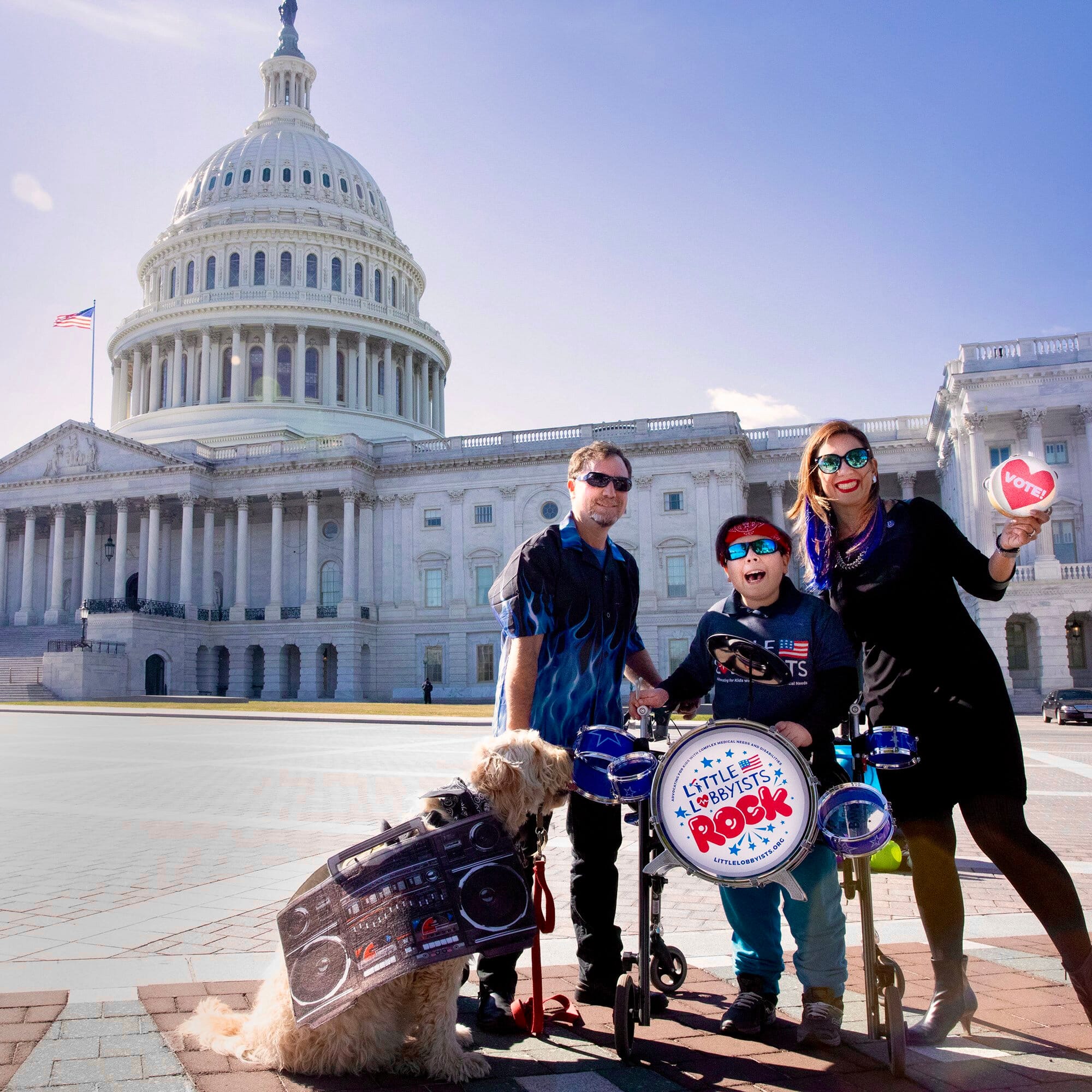A Little Lobbyists family poses in front of the U.S. Capitol, accompanied by a dog and a drum set.
