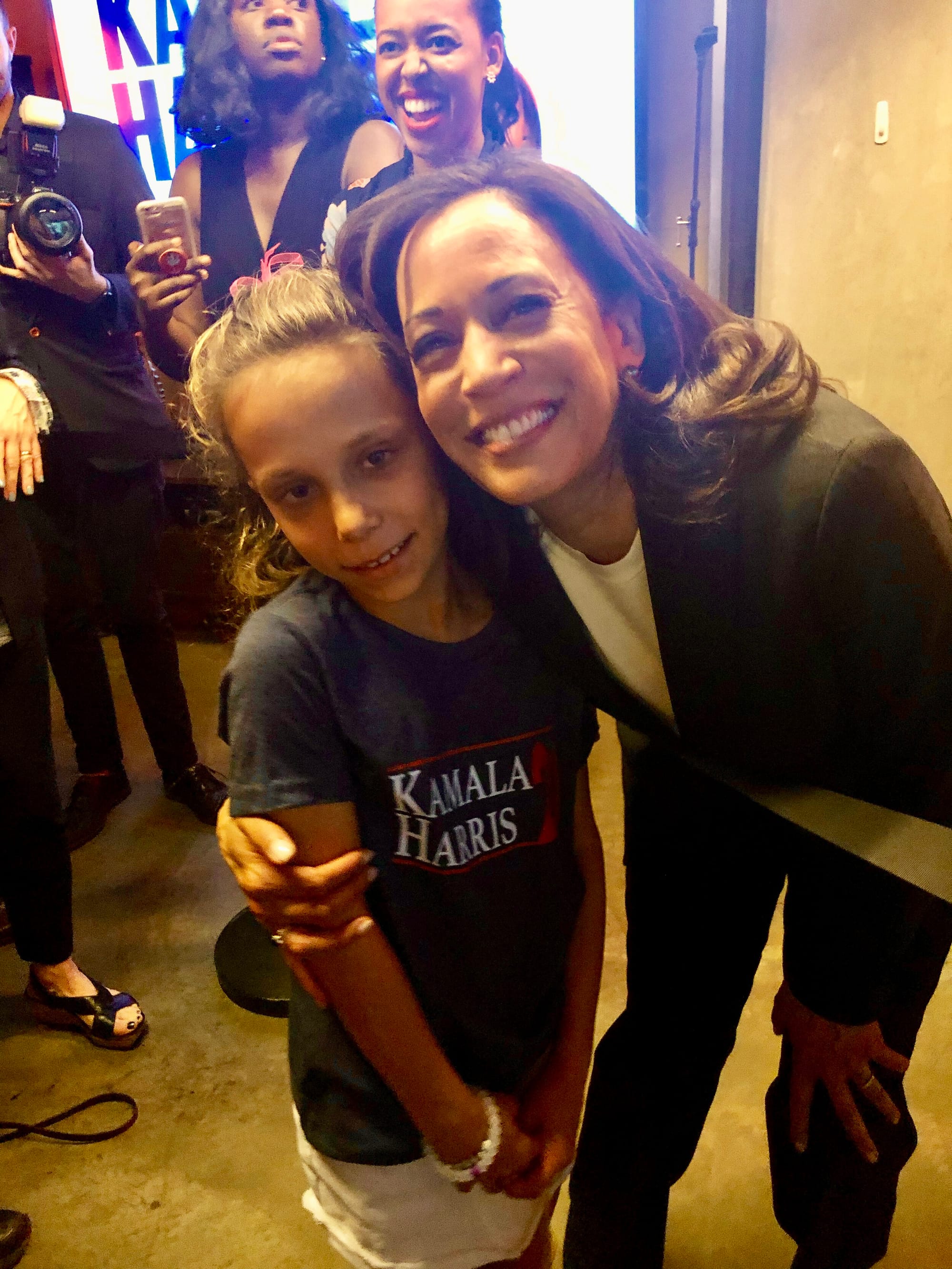 A U.S. Senator hugs a young girl wearing a Kamala Harris t-shirt.