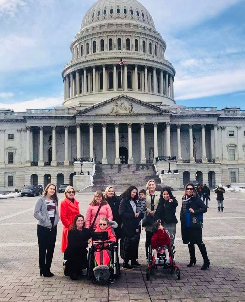 A group of Little Lobbyists families pose in front of the U.S. Capitol after meetings with representatives.