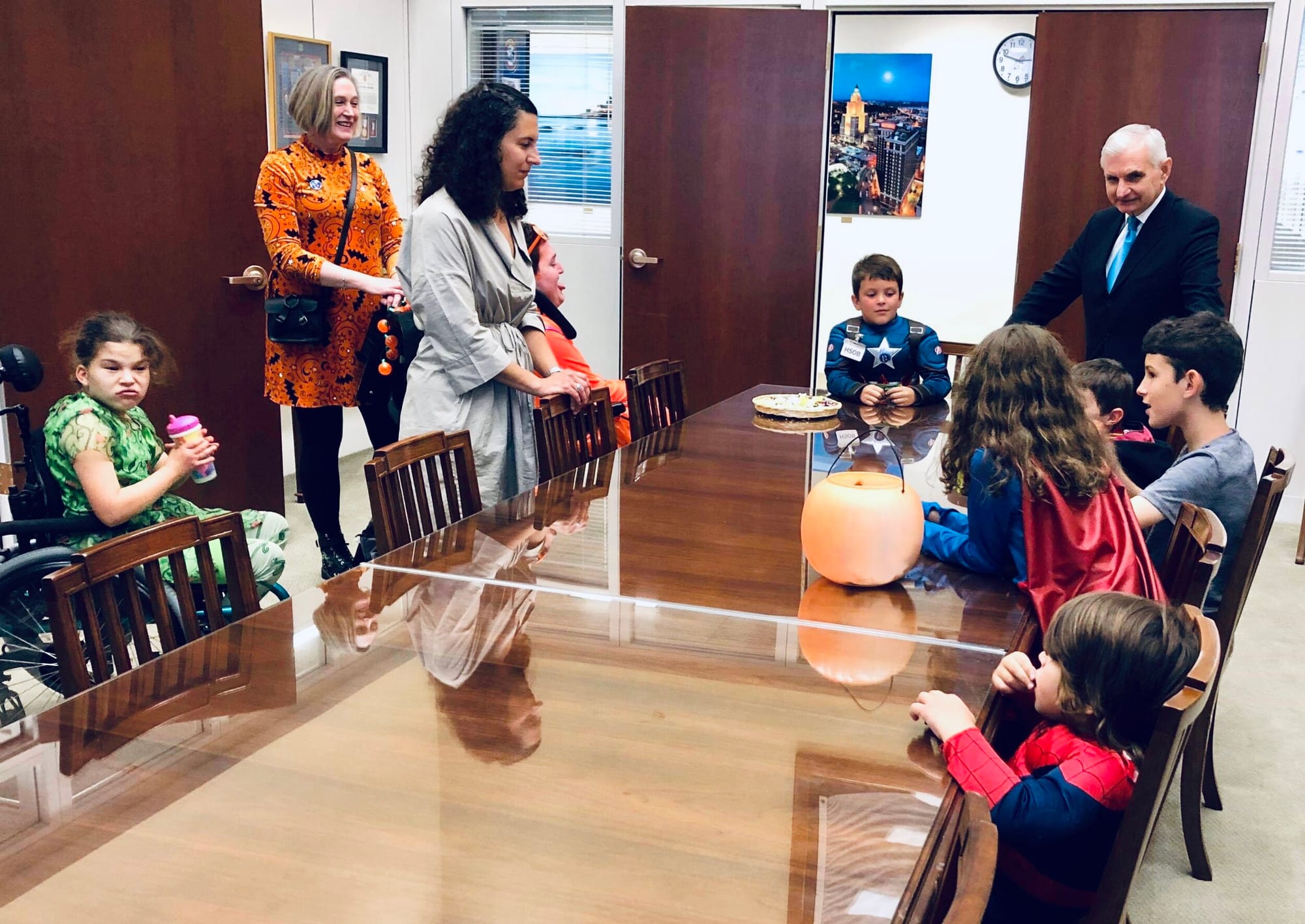 Little Lobbyists families sit around a table in a congressional office while telling their health care stories to a congressman.