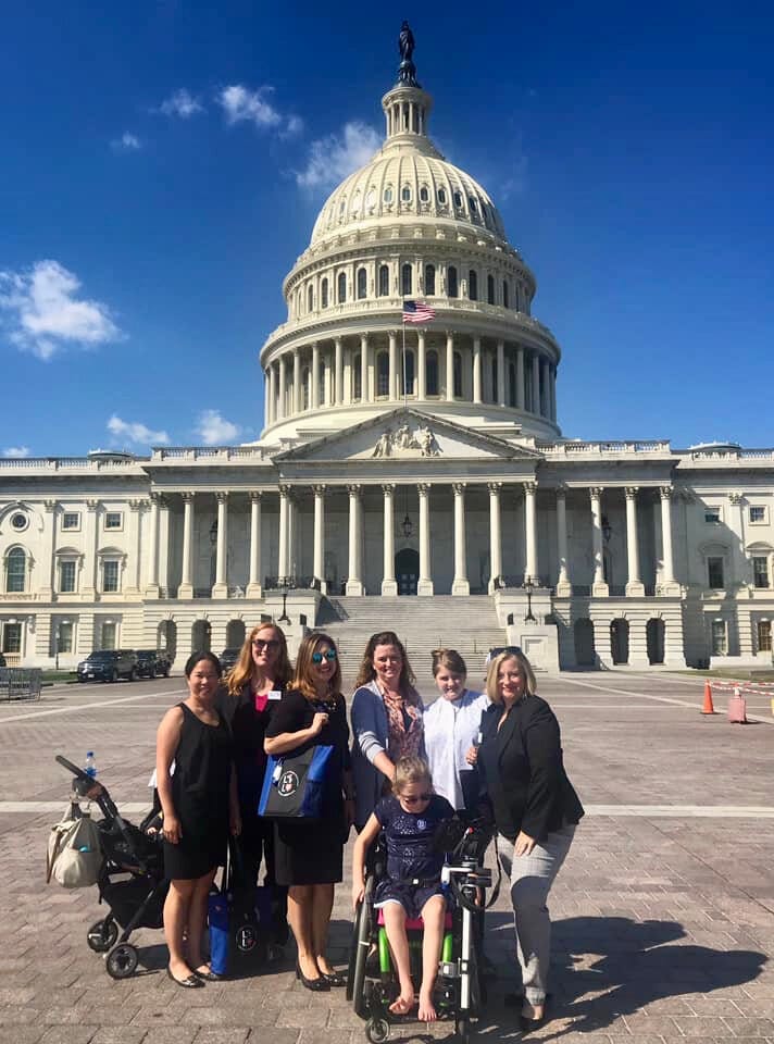 A group of Little Lobbyists families pose in front of the U.S. Capitol building.