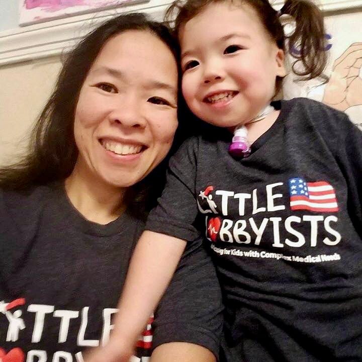 A founder of Little Lobbyists poses with her daughter. Both wear navy blue t-shirts with the LL logo.