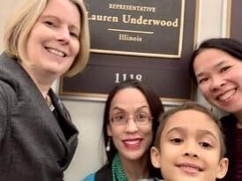 Little Lobbyists pose in front of the name plaque of a U.S. congressional office.
