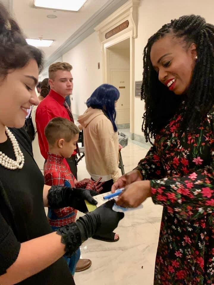 A new member of Congress signs an autograph for a Little Lobbyists teenager.