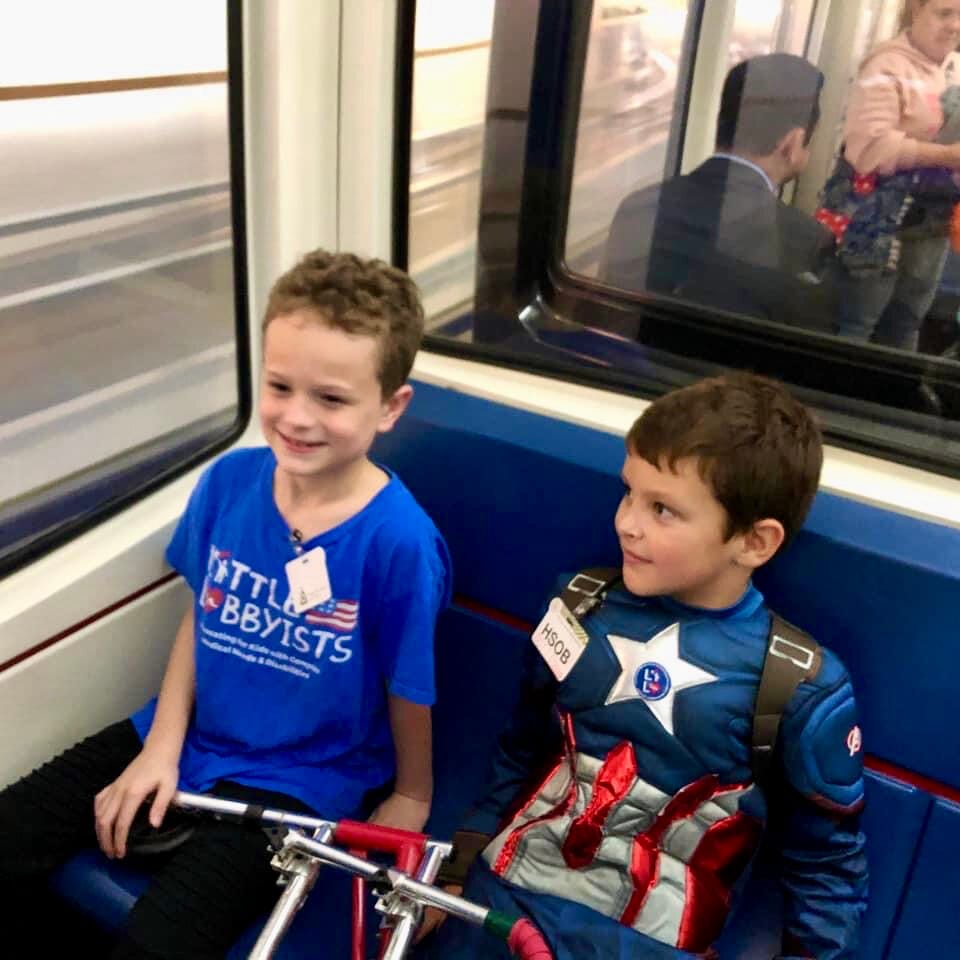 Two young boys smile while riding the Senate train underneath the U.S. Capitol.