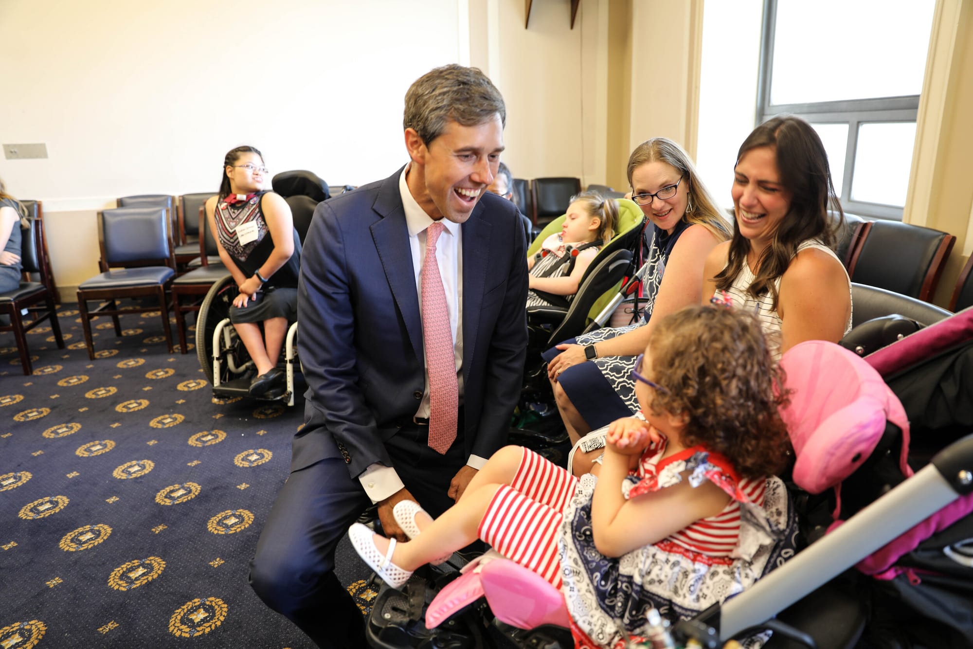 Congressman kneels to meet a Little Lobbyists child.