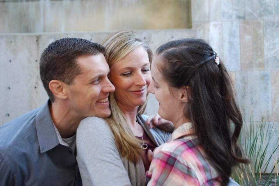 16-year-old Taryn and her mom and dad embrace.
