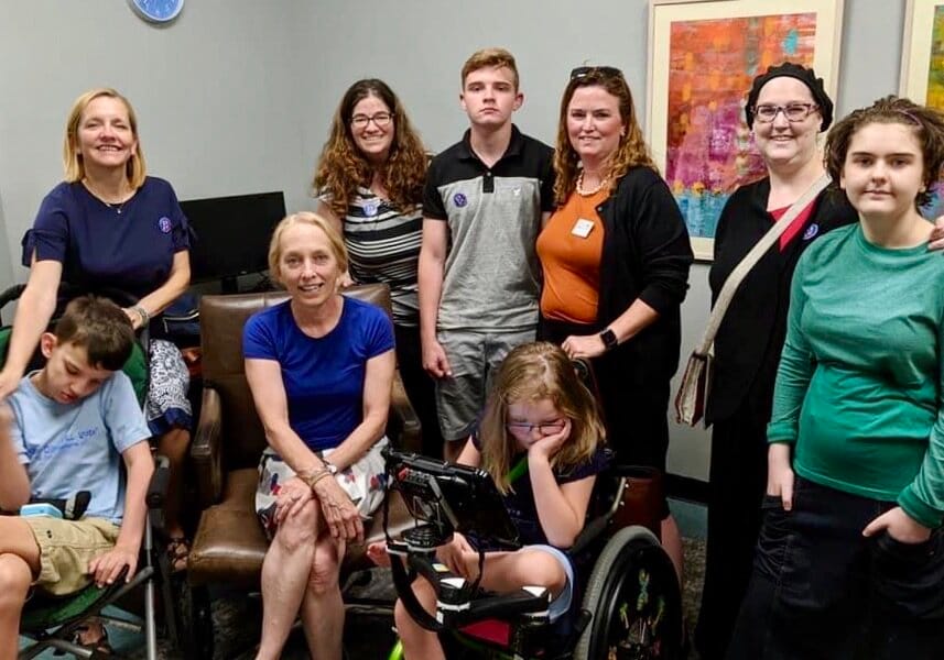 Mary Gay Scanlon is seated between Kevin and Abby, who are both in their wheelchairs. Little Lobbyists moms stand in the back, with Collin at center.
