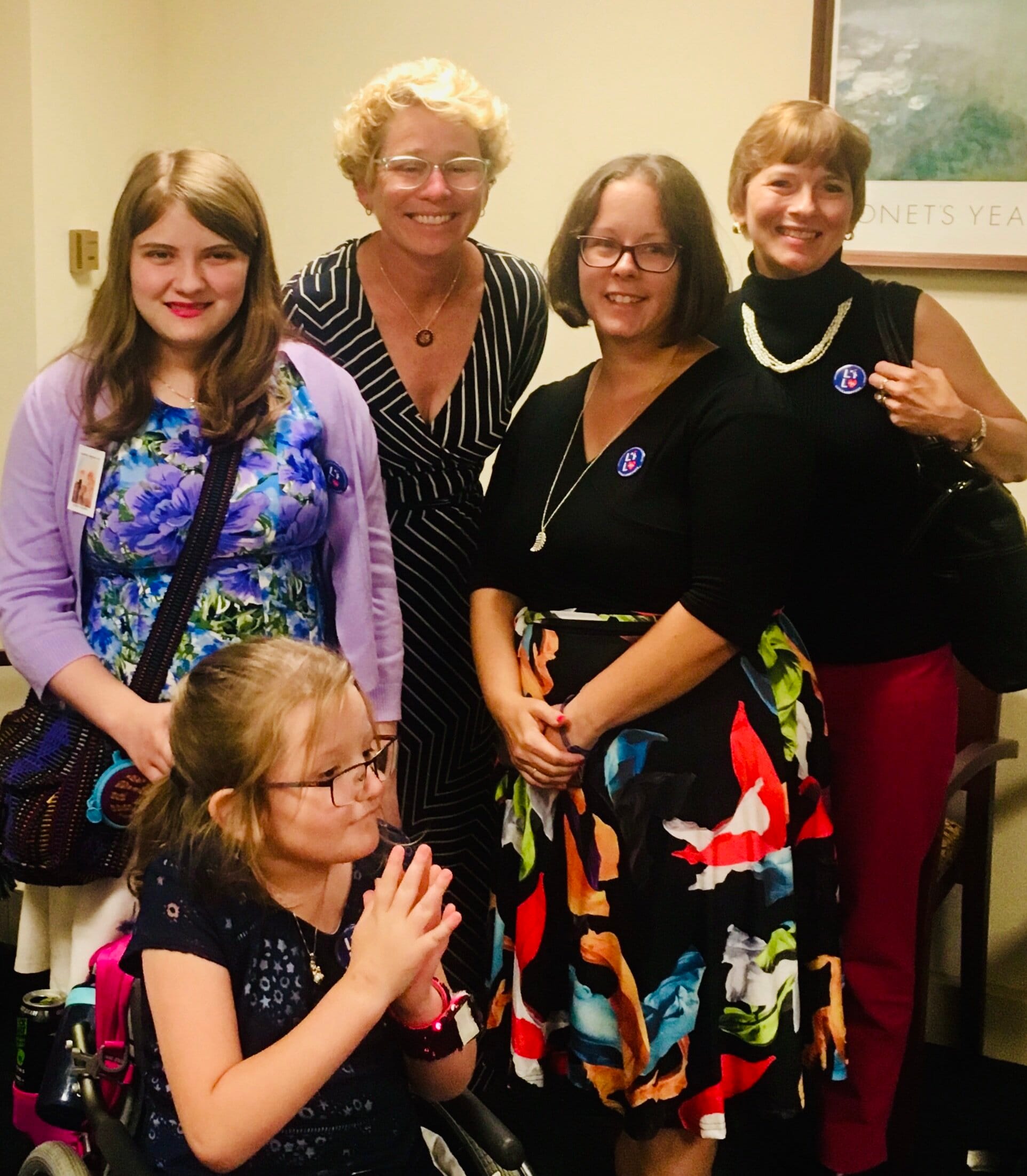 Chrissy Houlahan stands with Little Lobbyists moms Lisa and Sharon as well as Bridget. Abby is seated in her wheelchair and clapping her hands.