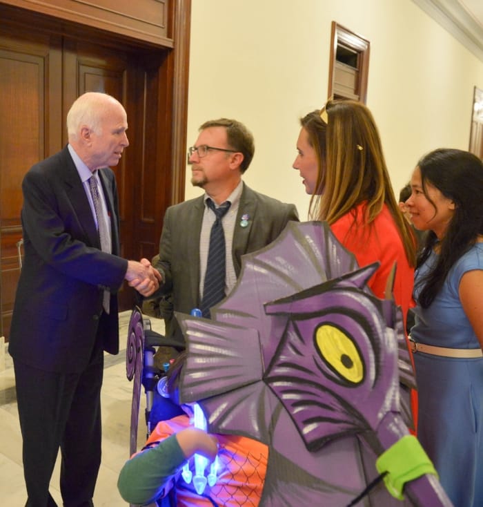 My husband Brian shaking hands with Senator McCain. This is Brian's "wow" face. Because, wow. Also, it was Halloween and we went trick-or-treating in the Senate (as one does) and that is a giant seahorse costume we made for Simon's wheelchair. He wa…