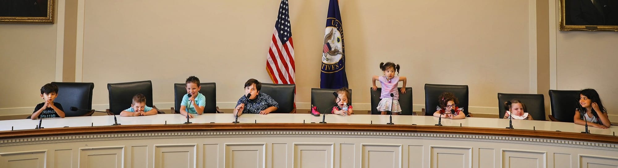 Little Lobbyists children sitting in chairs usually reserved for legislators in a hearing room in the U.S. Capitol