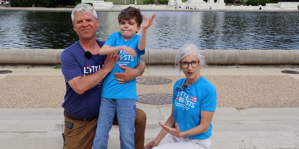 A smiling Charlie and his parents at the U.S. Capitol.